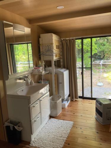eine Küche mit Spüle, Kühlschrank und Fenster in der Unterkunft Nabiki in Hongu