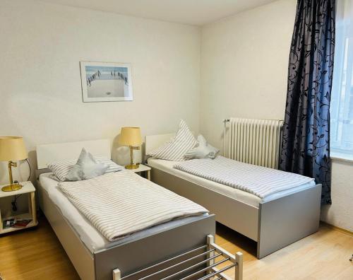 a bedroom with two beds and a window at Pension Merkle in Ichenhausen