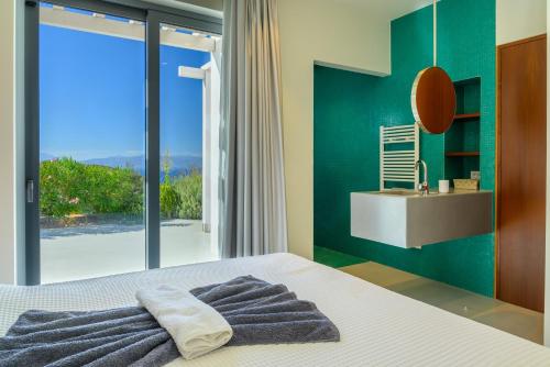 a bedroom with a bed with a mirror and a sink at Luxury Villa with Panoramic Sea Views in Thólos