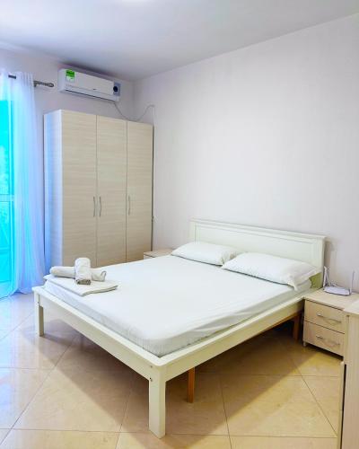 a bedroom with a large white bed in a room at Residence Kullat in Velipojë