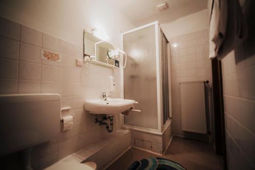 a bathroom with a sink and a toilet and a shower at Landhotel Herscheider Mühle in Herscheid