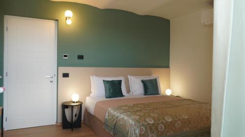 a bedroom with a bed with a green wall at Casa Panerole in Novello