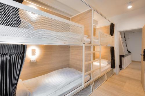 a room with two bunk beds and a staircase at The Ostel Hostel Bangkok in Bangkok