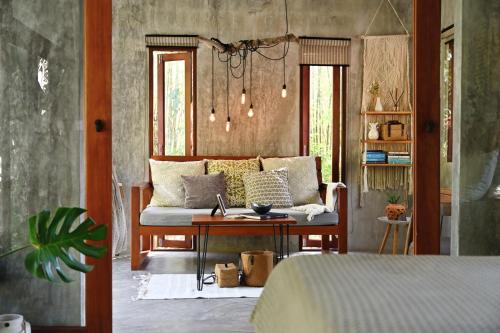 a living room with a couch and a table at Boutique Jungle Villa - Baan ChaOm in Ko Lanta
