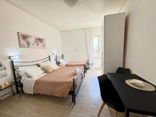 a bedroom with two beds and a dining table at Affittacamere Il Veliero in Levanto