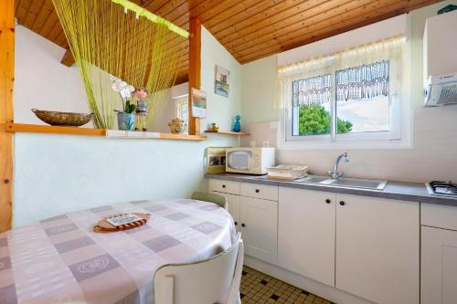 a small kitchen with a table and a sink at Studio à La Ferme in Sémussac