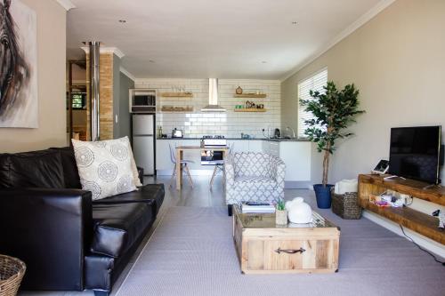 a living room with a couch and a table at Rest at Chabivin in Stellenbosch