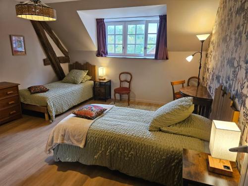 a bedroom with two beds and a window at Le Mariotte in Pont-et-Massène