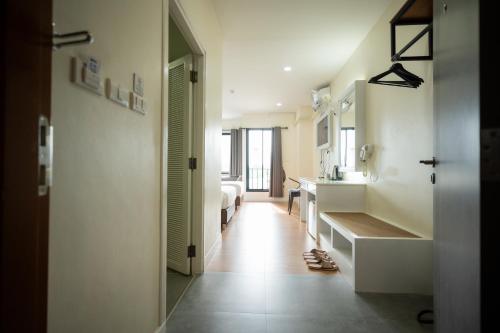 a bathroom with a sink and a bed and a mirror at โรงแรมต้นเงิน in Khon Kaen