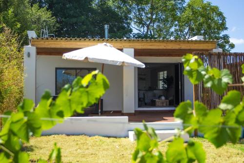 a small house with an umbrella in a yard at Rest at Chabivin in Stellenbosch