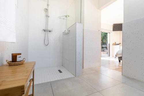 a white bathroom with a shower and a wooden table at Wartburg Guesthouse in Wartburg