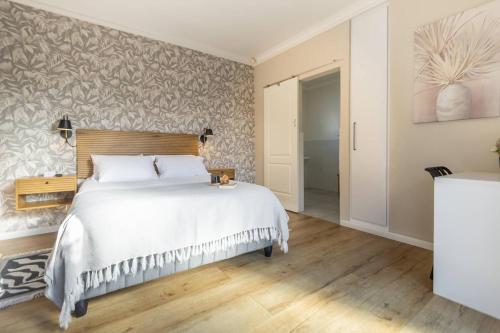 a bedroom with a large white bed and a wall at Wartburg Guesthouse in Wartburg