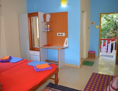a room with a bed and a desk in it at Namaste Yoga Farm in Gokarna