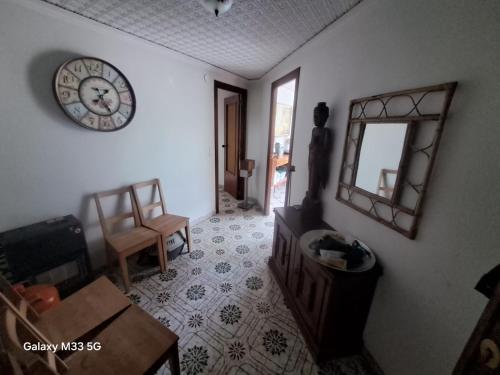 a living room with a clock on the wall at Mountain View Village Life in Bárig