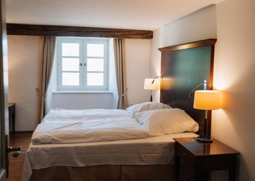 a bedroom with a large bed with a window at Schloss Maierhofen in Painten