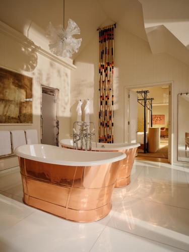 a large bathroom with a tub in the middle at Coworth Park - Dorchester Collection in Ascot