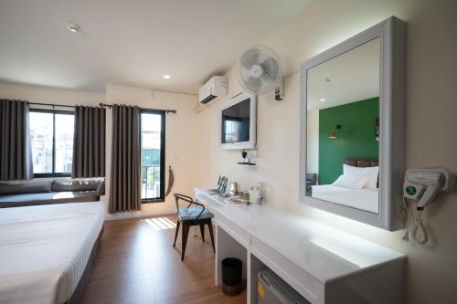 a bathroom with a sink and a large mirror at โรงแรมต้นเงิน in Khon Kaen