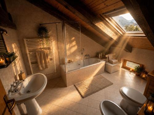 a bathroom with a tub and a toilet and a sink at Casa Zarabara in Arta Terme