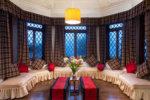 a living room with white couches and red pillows at Scottish Planter Bungalow- Thema Collection in Nuwara Eliya
