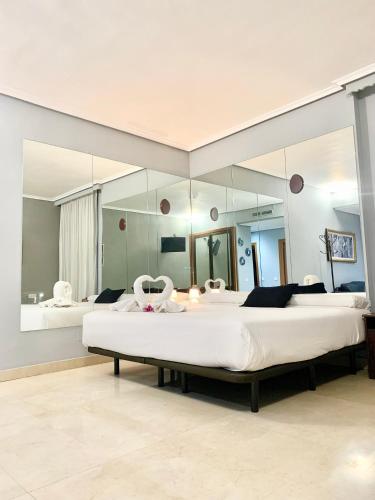 ein großes Schlafzimmer mit zwei Betten und einem großen Spiegel in der Unterkunft Hotel Humanes in Humanes de Madrid