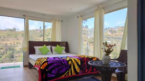 a bedroom with a bed with a table and windows at The Plum in Mukteshwar