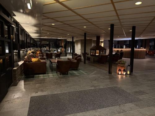 a lobby with couches and tables in a building at Saxnäsgården Hotell in Saxnäs