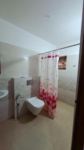 a bathroom with a toilet and a shower curtain at Captains Cabin, Alleppey- A Premium Backwater Mansion in Alleppey