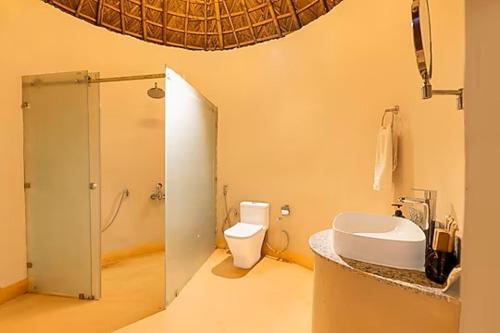 a bathroom with a toilet and a sink and a shower at Forest Mud Villas in Haridwār