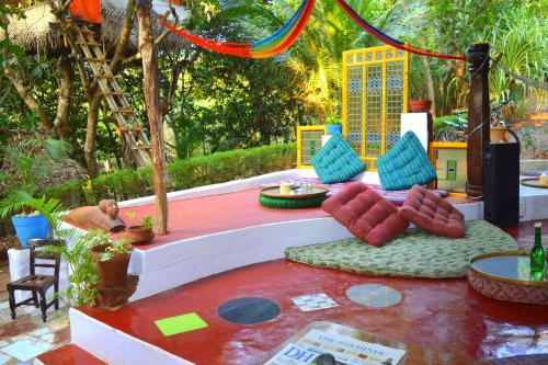 a living room with a table and chairs on a patio at Namaste Yoga Farm in Gokarna