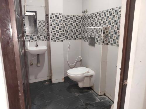 a bathroom with a toilet and a sink at AB Merridien in Coimbatore