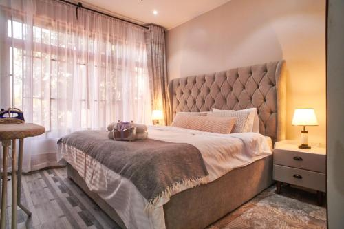 a bedroom with a large bed and a window at Bustani Home Studio in Arusha