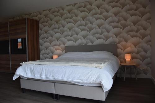 a bedroom with a bed with a wall covered in feathers at Bed & Bresjes in Breskens