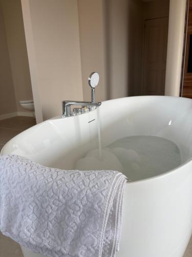 a white bath tub with a white towel on it at Bed & Bresjes in Breskens
