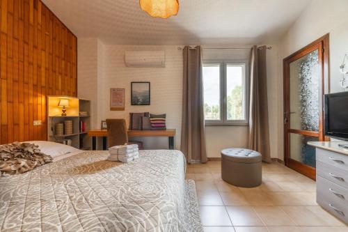 a bedroom with a bed and a television in it at Luxi noa in Quartu SantʼElena