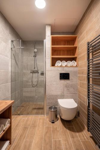 a bathroom with a shower and a toilet at Resort Aurum in Černý Dŭl