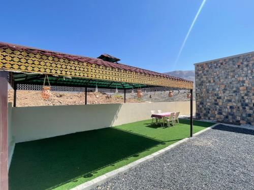 a patio with a table and chairs next to a building at Jabal Shams, the summit house in Misfāh
