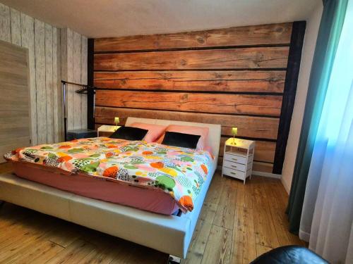 a bedroom with a bed with a wooden wall at Ferienwohnung 1890 in Dettelbach