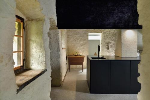 a kitchen with a black counter and a window at Alpine Contrapposto in Solčava
