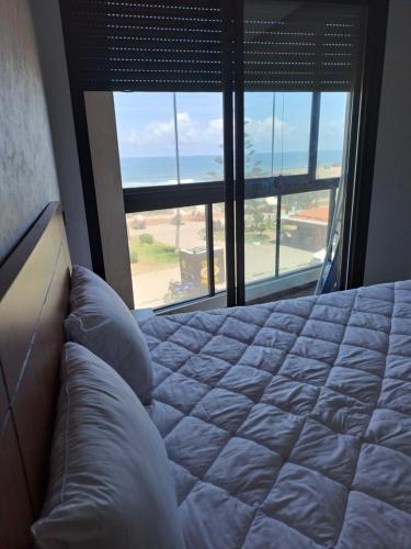 a bedroom with a bed and a view of the ocean at Blue Horizon Mansouriah in Mohammedia