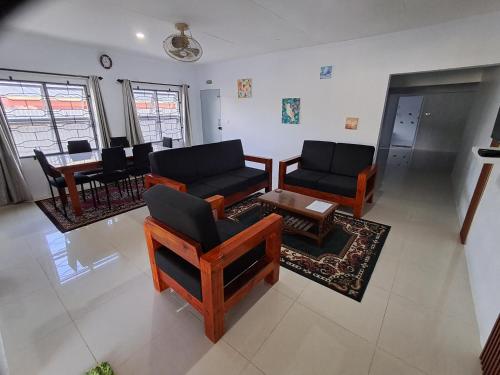 a living room with couches and chairs and a table at Favored Haven in Sarava