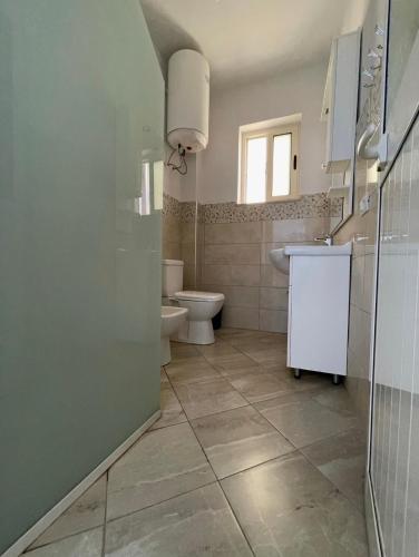 a bathroom with a toilet and a sink at Residence Kullat in Velipojë