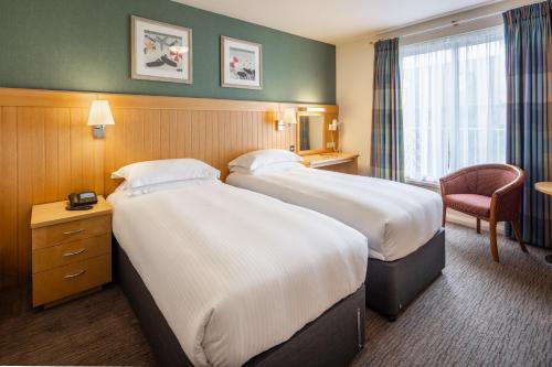 a hotel room with two beds and a chair at Merton Hotel in St. Saviour