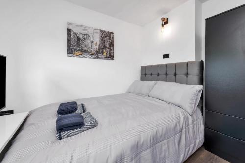a bedroom with a bed with a blue towel on it at Modern Cambridge Studio in Milton