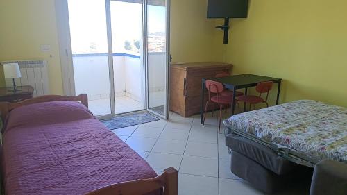 a room with two beds and a table and a tableablish at Il respiro del mare in Montesilvano