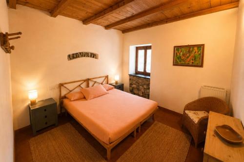 a bedroom with a bed and a chair and a window at Agriturismo Giandriale in Tavarone