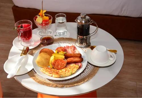 a white plate of breakfast food on a table at Bustani Tulivu in Bungoma