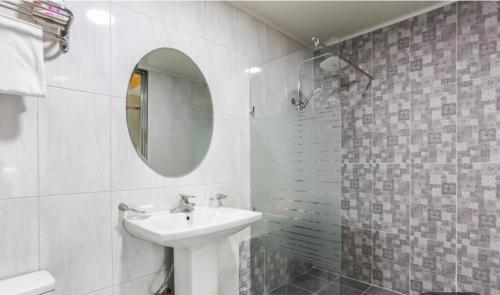 a white bathroom with a sink and a mirror at Hive Hotel in Tongduch'ŏn