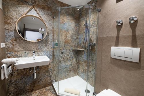 a bathroom with a shower and a sink and a mirror at B&B Fischerstüble - adults only in Hagnau