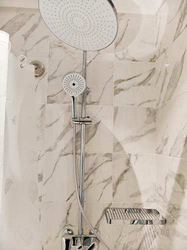 a shower with a shower head in a bathroom at Central Park Hotel 中央公园酒店 in Jalal-Abad