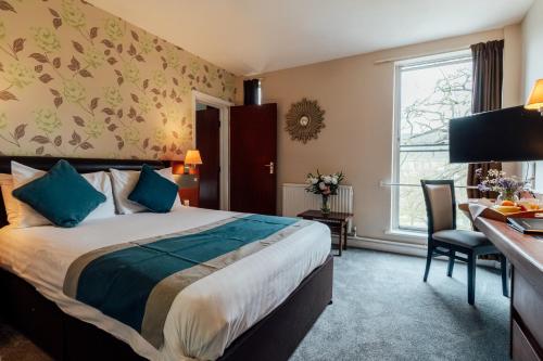 a hotel room with a bed and a desk at St James Hotel in Grimsby